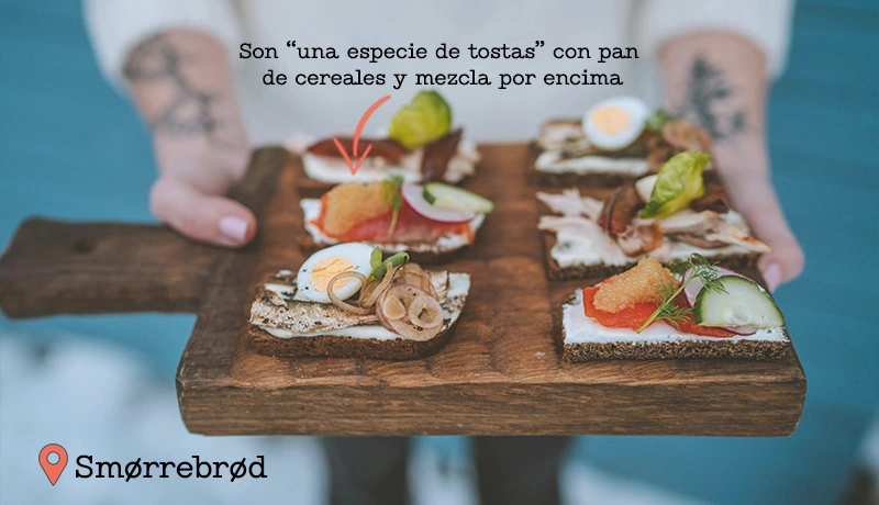 Varios tipos de Smørrebrød danés sobre una tabla de madera