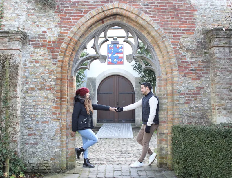 Inma y Álex posando bajo un arco de ladrillo en las ruinas de la Abadía de San Bavón de Gante