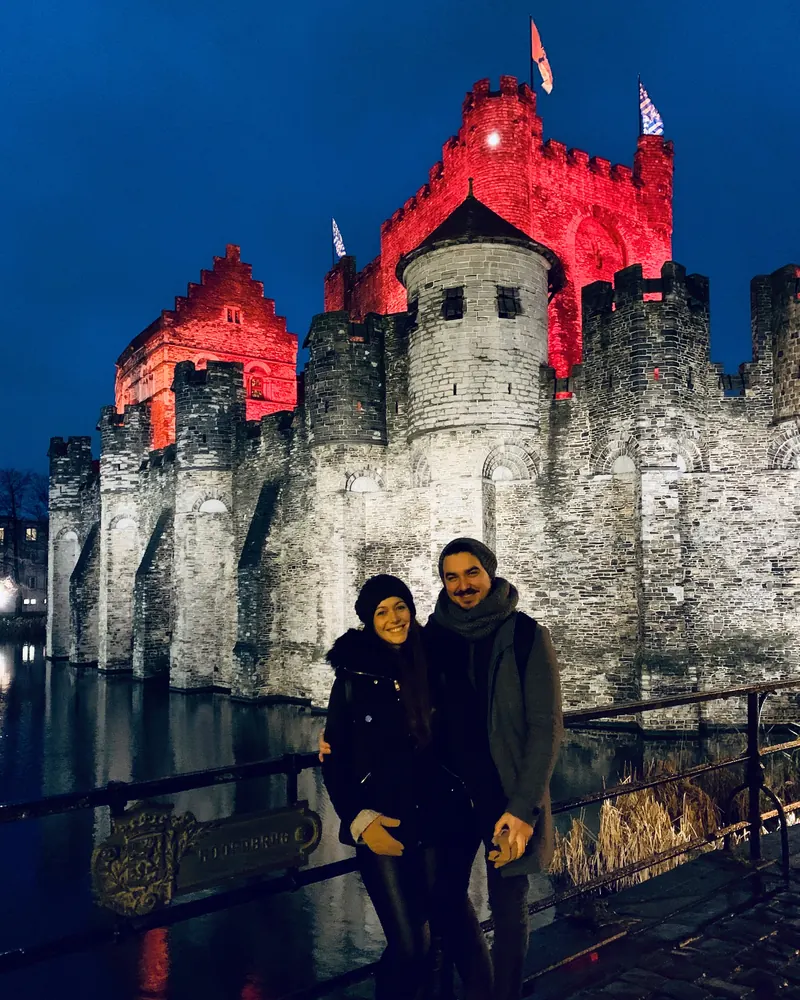 Inma y Álex delante del castillo de Gravensteen de Gante iluminado de noche