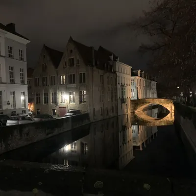 El hotel Ter Brughe de Brujas de noche, junto al canal, con su reflejo en el agua
