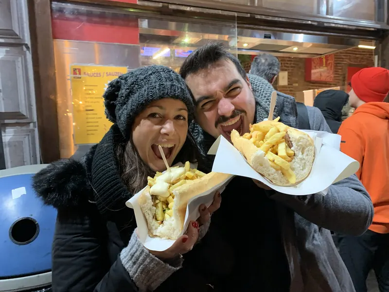 Inma y Álex con dos Mitraillettes de Fritland, en Bruselas, rellenos de carne y patatas fritas