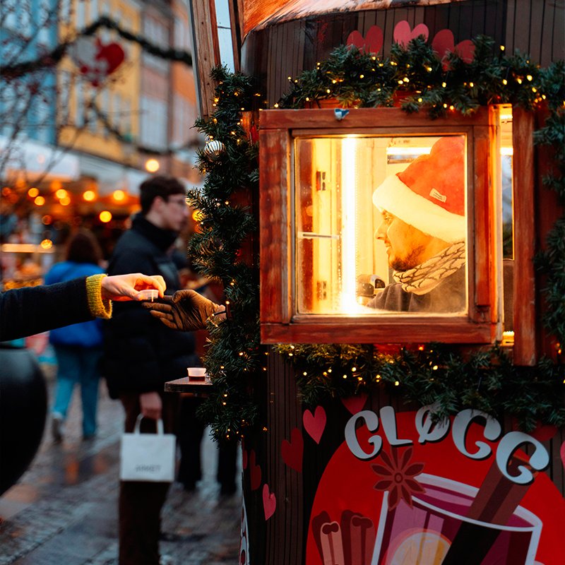 Puesto de glögg y vino caliente en el mercado de Navidad de Nyhavn, Copenhague, con tazas listas para servir.