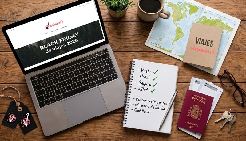 Portátil con la guía del Black Friday de viajes de Viajamos2, pasaporte, mapa, billetes y libreta con la lista del viaje