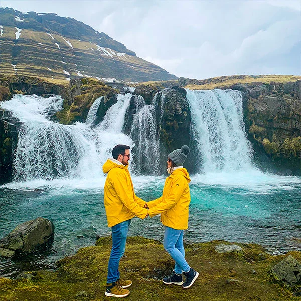 La pareja de viajeros de Viajamos2 frente a una cascada en Islandia