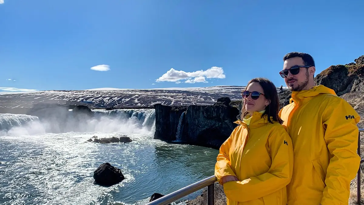 Viajeros disfrutando de las vistas panorámicas de la cascada Goðafoss en Islandia
