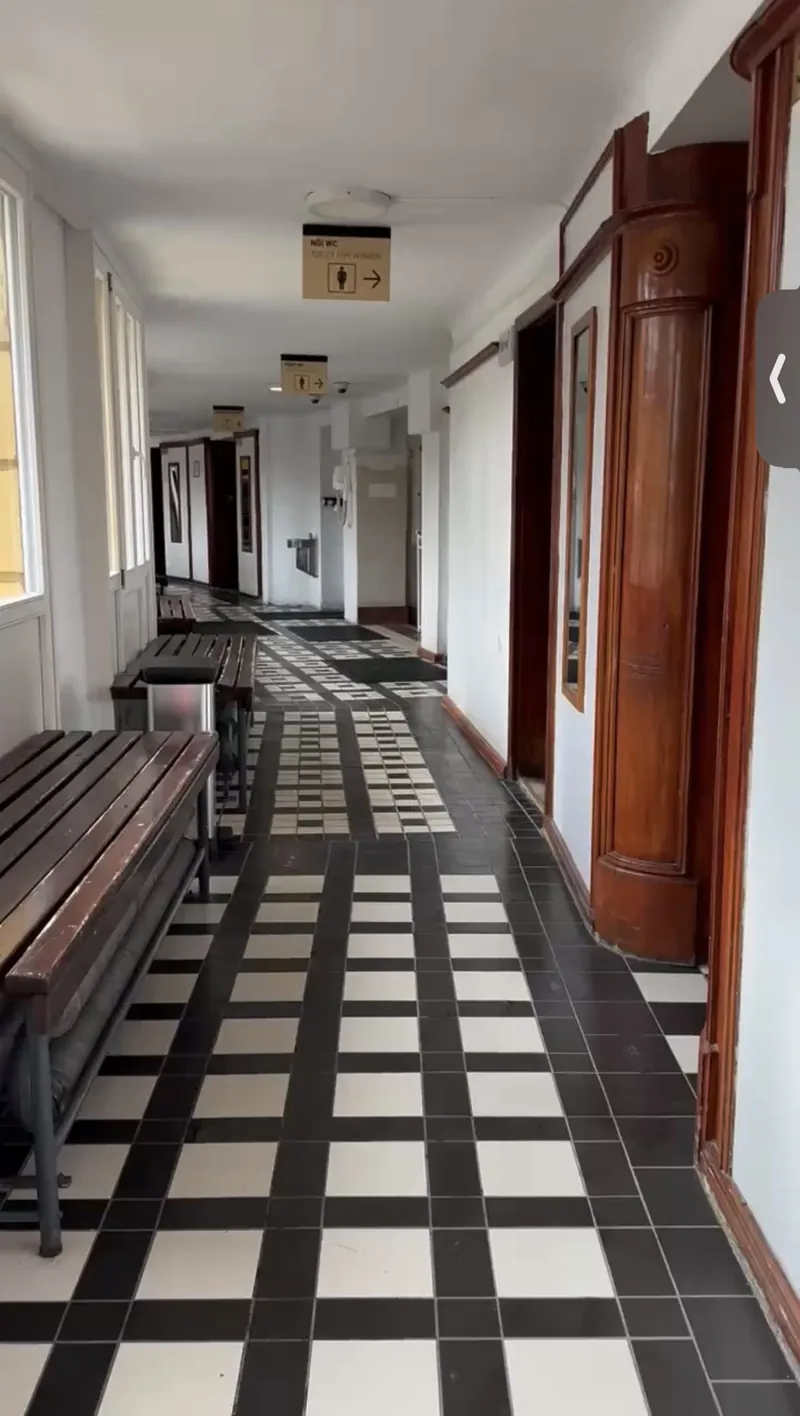 Pasillo de las cabinas privadas de los baños Széchenyi, con suelo de baldosas blancas y negras