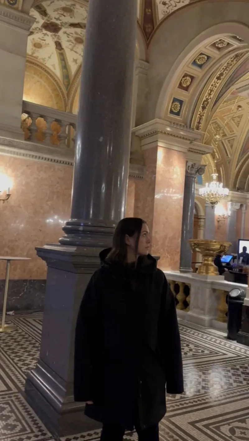 Inma en el vestíbulo de la Ópera de Budapest, entre columnas de mármol y techos pintados