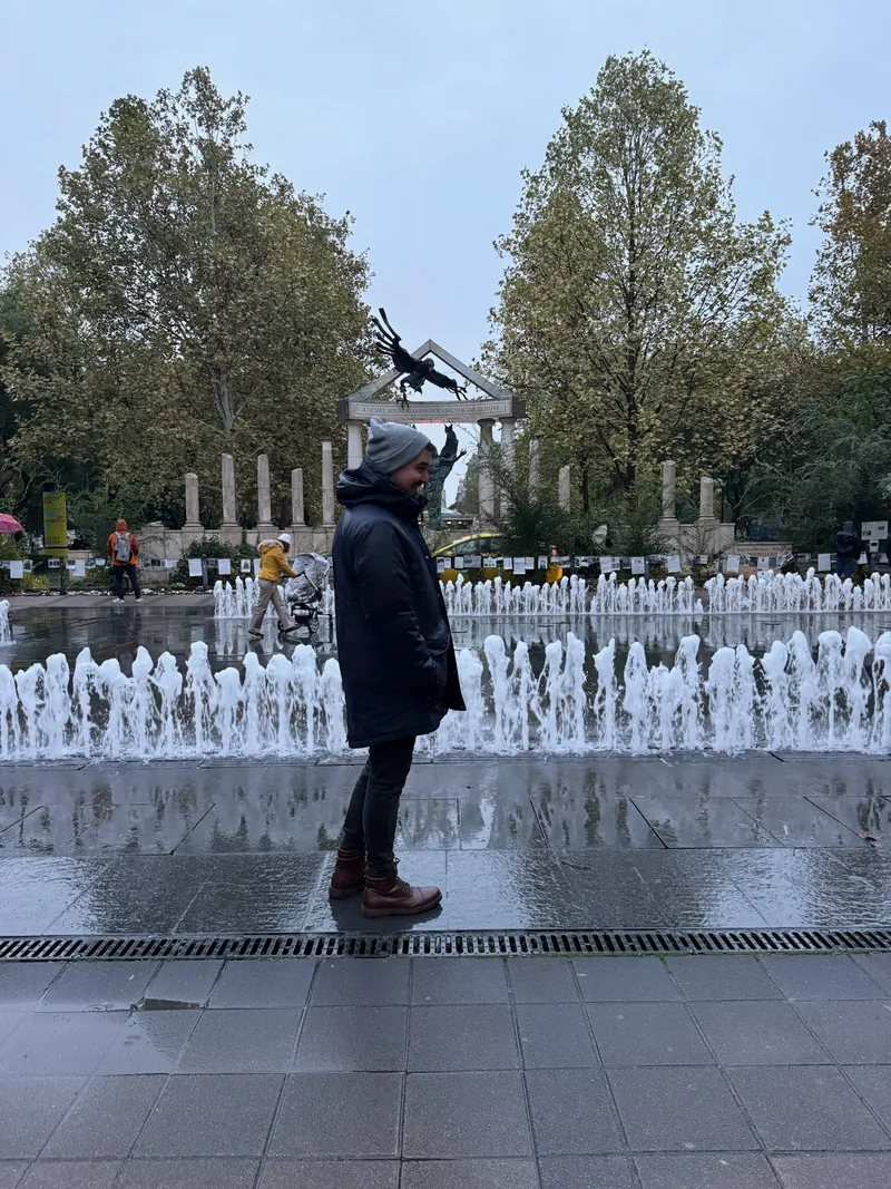 Álex en la plaza de la Libertad de Budapest, con las fuentes y el monumento a las víctimas de la ocupación alemana al fondo