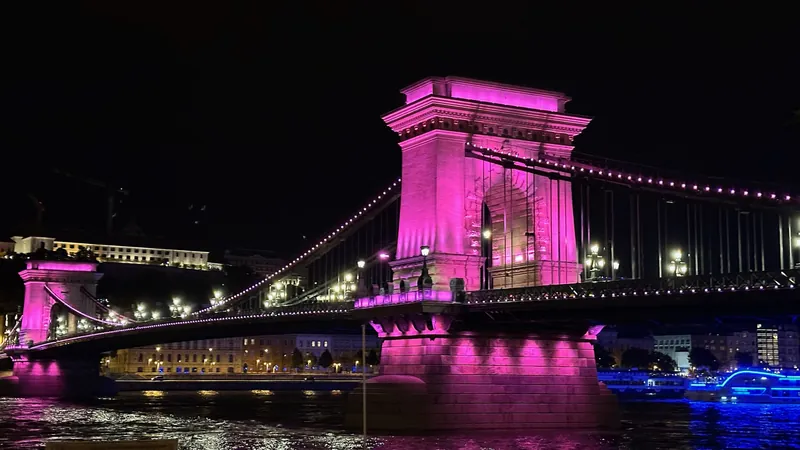 El Puente de las Cadenas de Budapest iluminado de noche sobre el Danubio, con el castillo de Buda al fondo