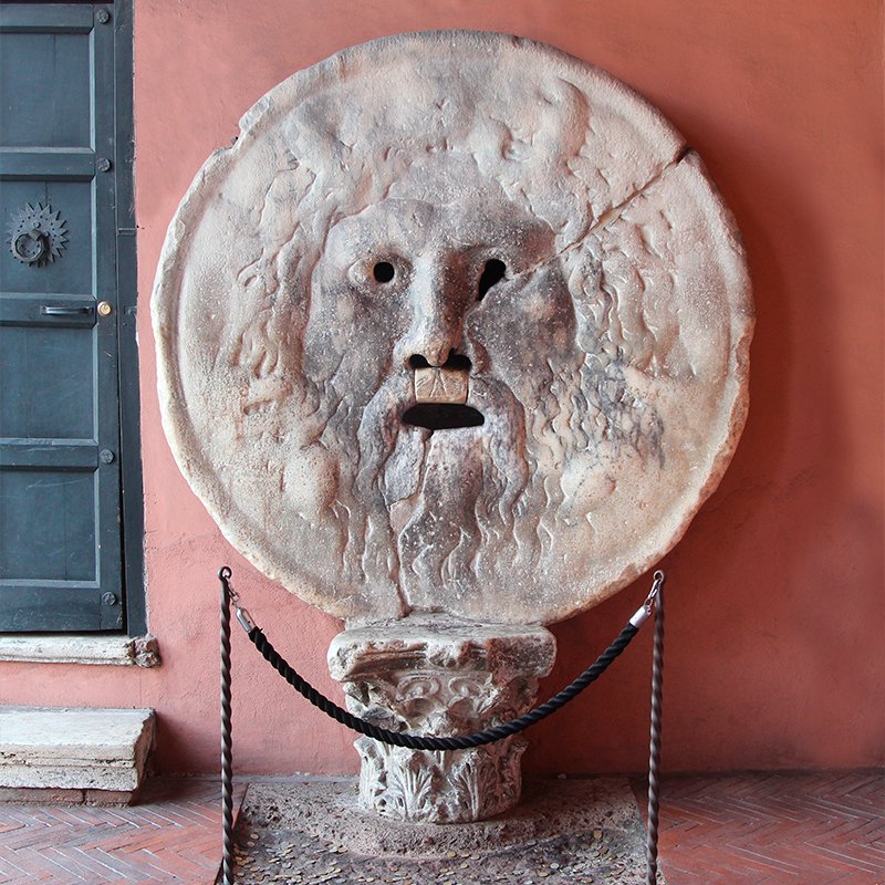 Detalle de la Bocca della Verità en Roma, con una mano intentando entrar en la boca.